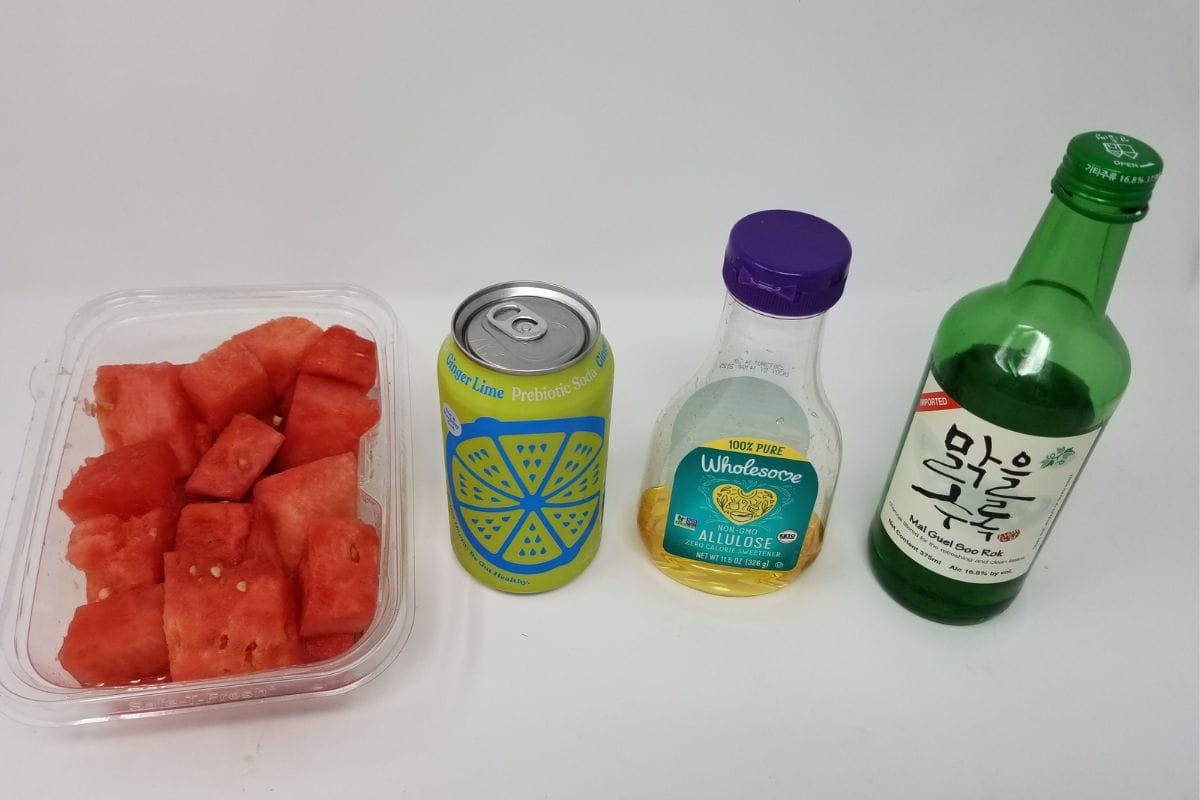 A bottle of soju, sugar syrup, carbonated ginger and lime in a can, and watermelon slices.