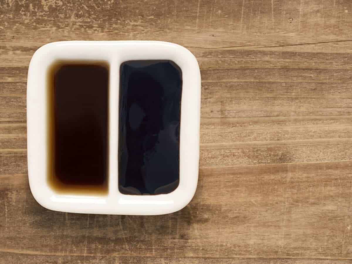 A small plate of dark and light soy sauce.