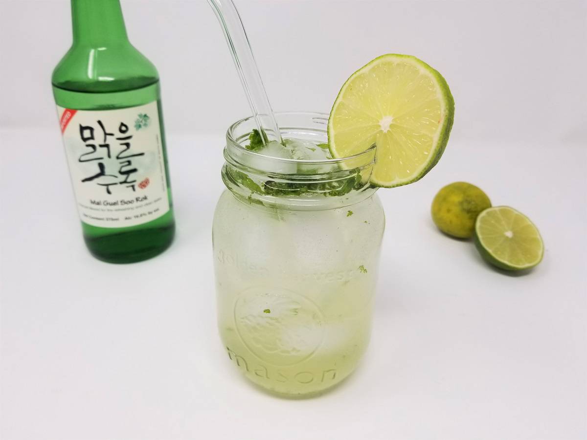 a mason jar of refreshingly cool glass of mojito made with soju and garnished with fresh mint