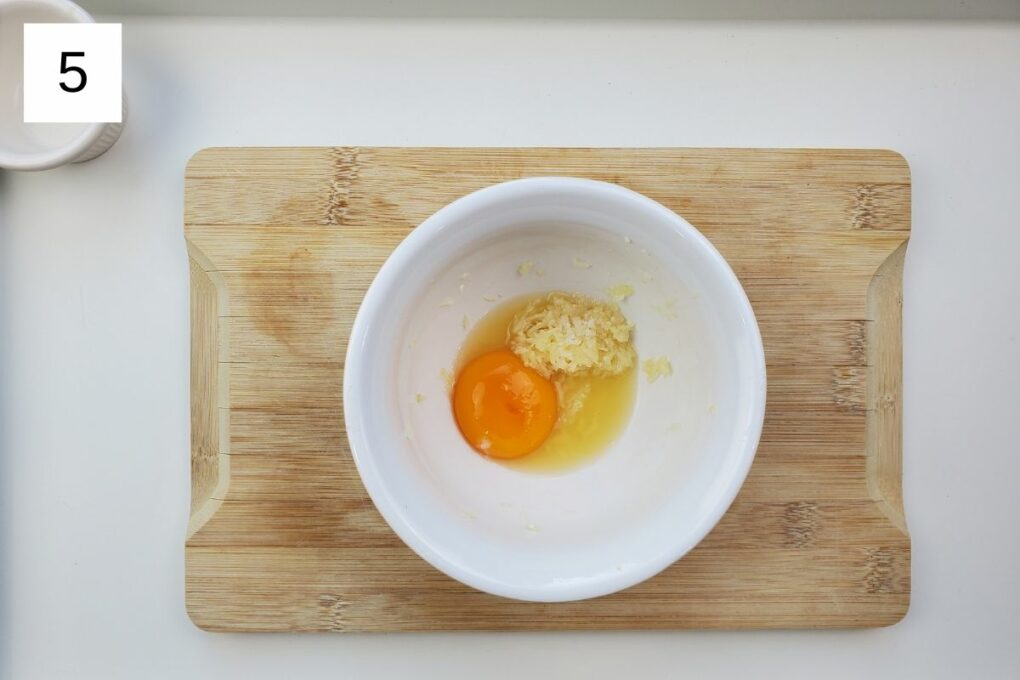 a mixture of yuzu juice, garlic, salt, and egg yolk in a white bowl