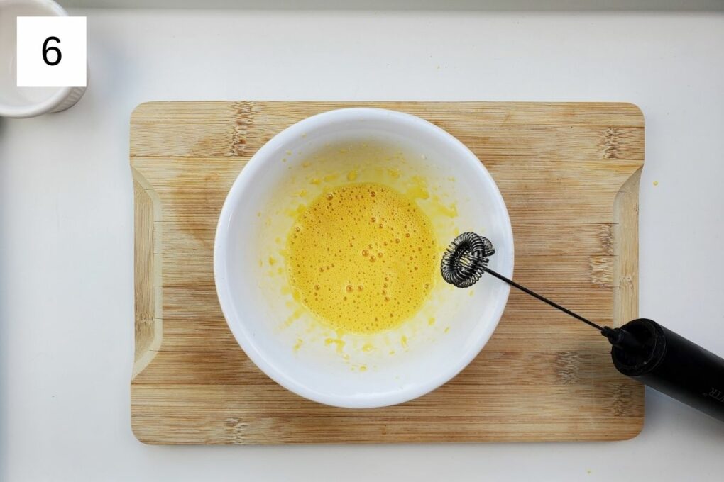 whisked mixture of yuzu juice, garlic, salt, and egg yolk in a white bowl