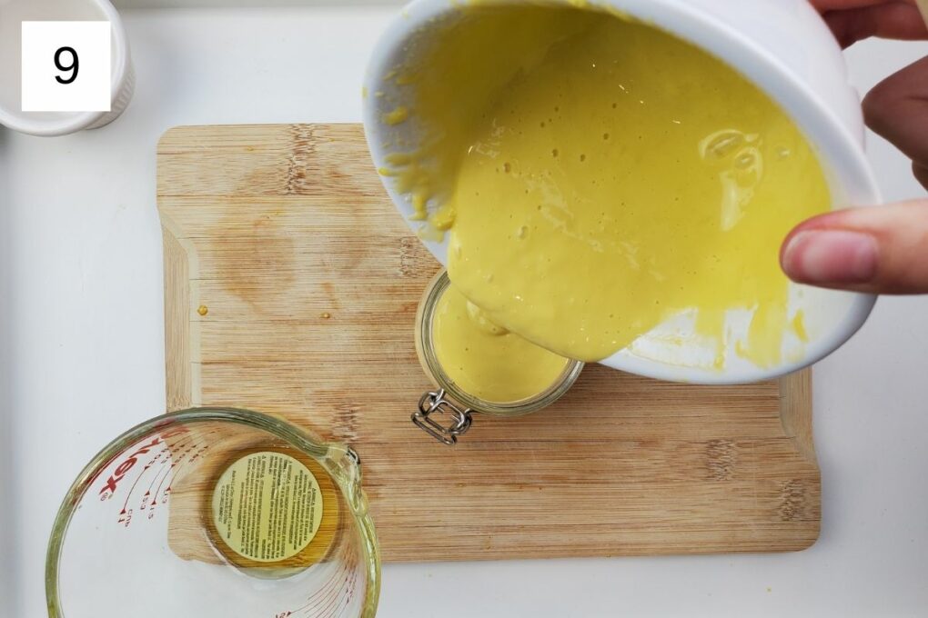 pouring the yuzu aioli mixture into a glass container