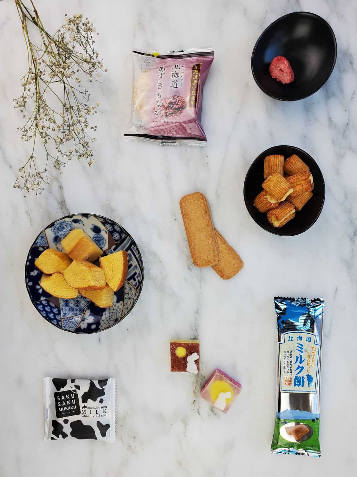 all of the sweet sakuraco snacks laid out on the table, some of them unwrapped.