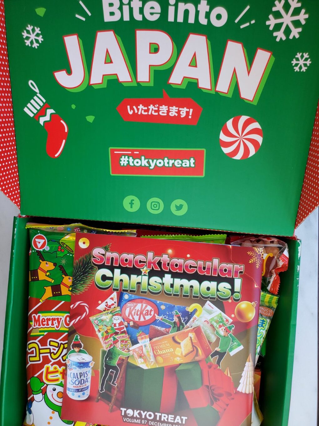 opened tokyo treat box with Christmas material at the top.