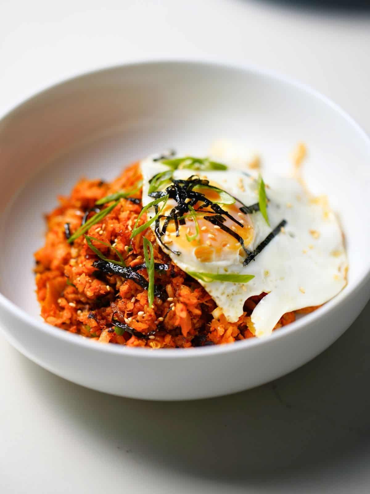 kimchi fried rice in a bowl topped with egg.