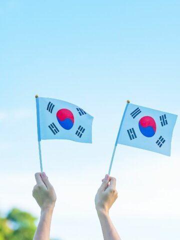 Hand holding Korea flag on nature background during National Foundation, Gaecheonjeol, public Nation holiday, National Foundation Day of Korea.