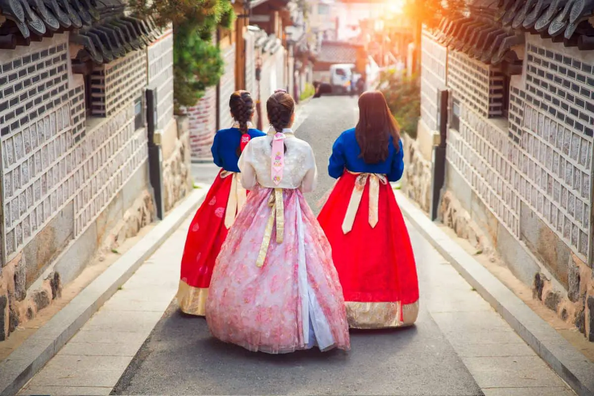 Women wearing hanbok in a traditional village.