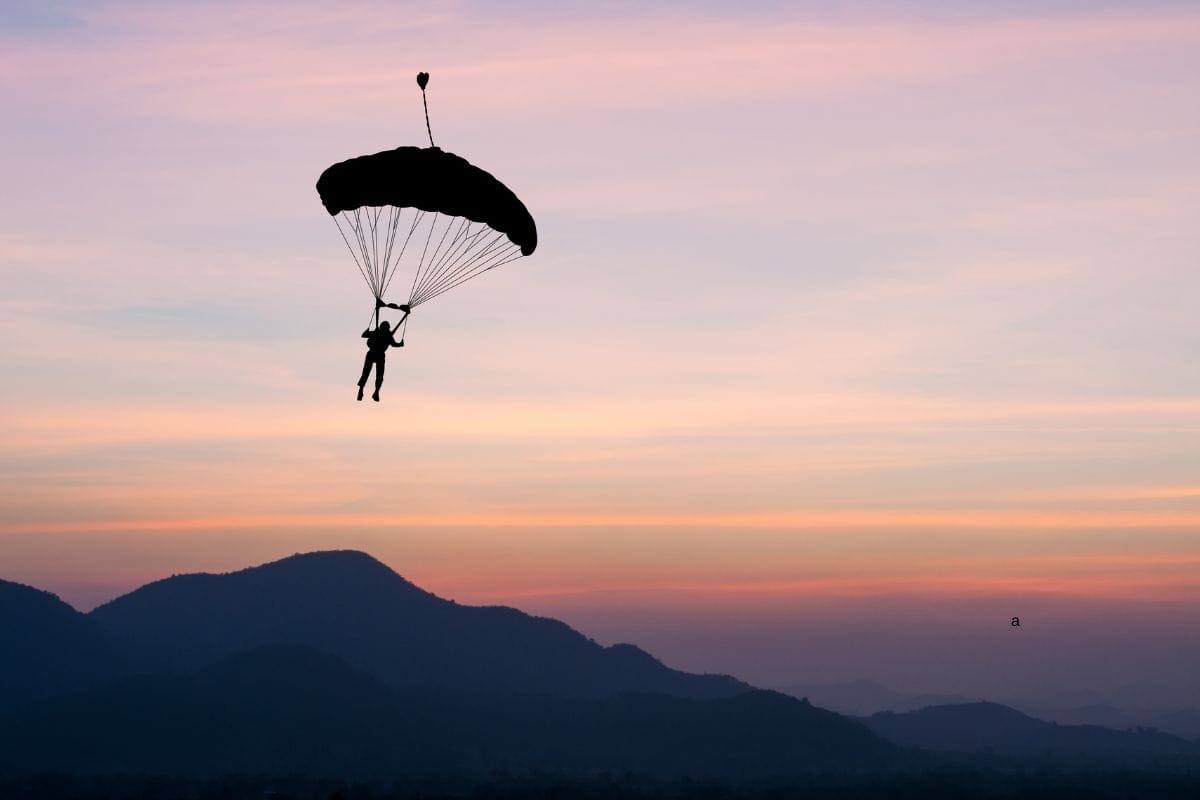 parachute at sunset silhouetted.