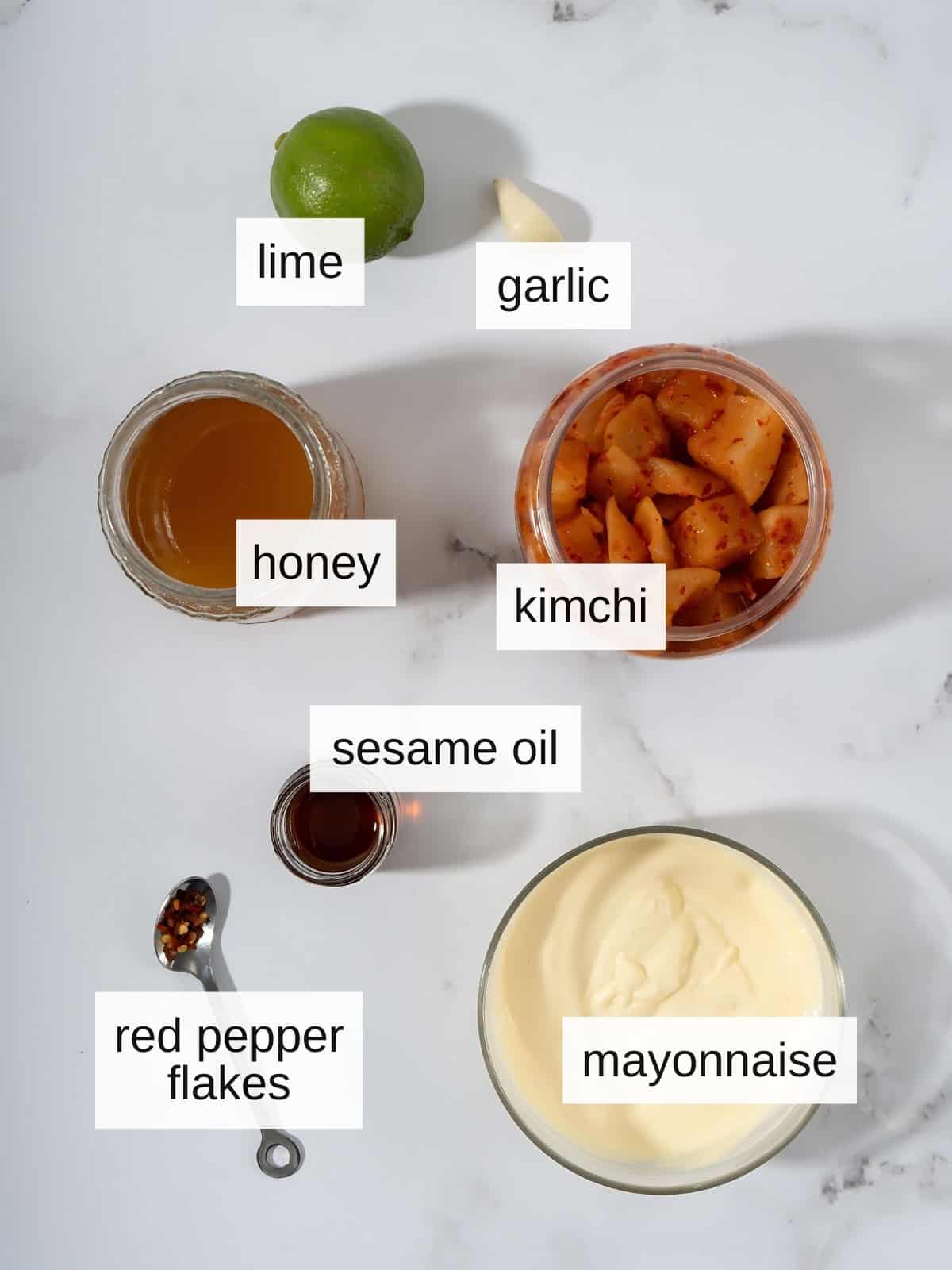 Kimchi aioli recipe including lime, garlic, honey, kimchi, sesame oil, red pepper flakes, and mayonnaise.