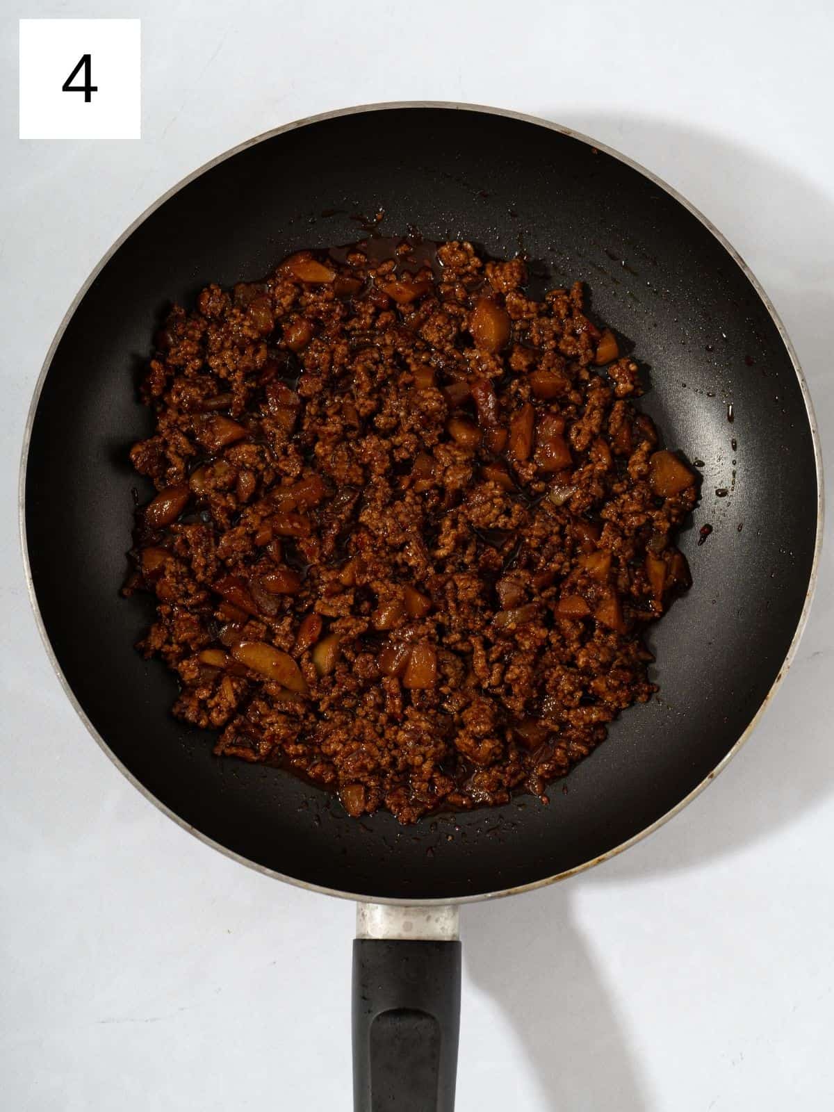 Cooked ground meat and kimchi covered with gochujang mixture in a pan.