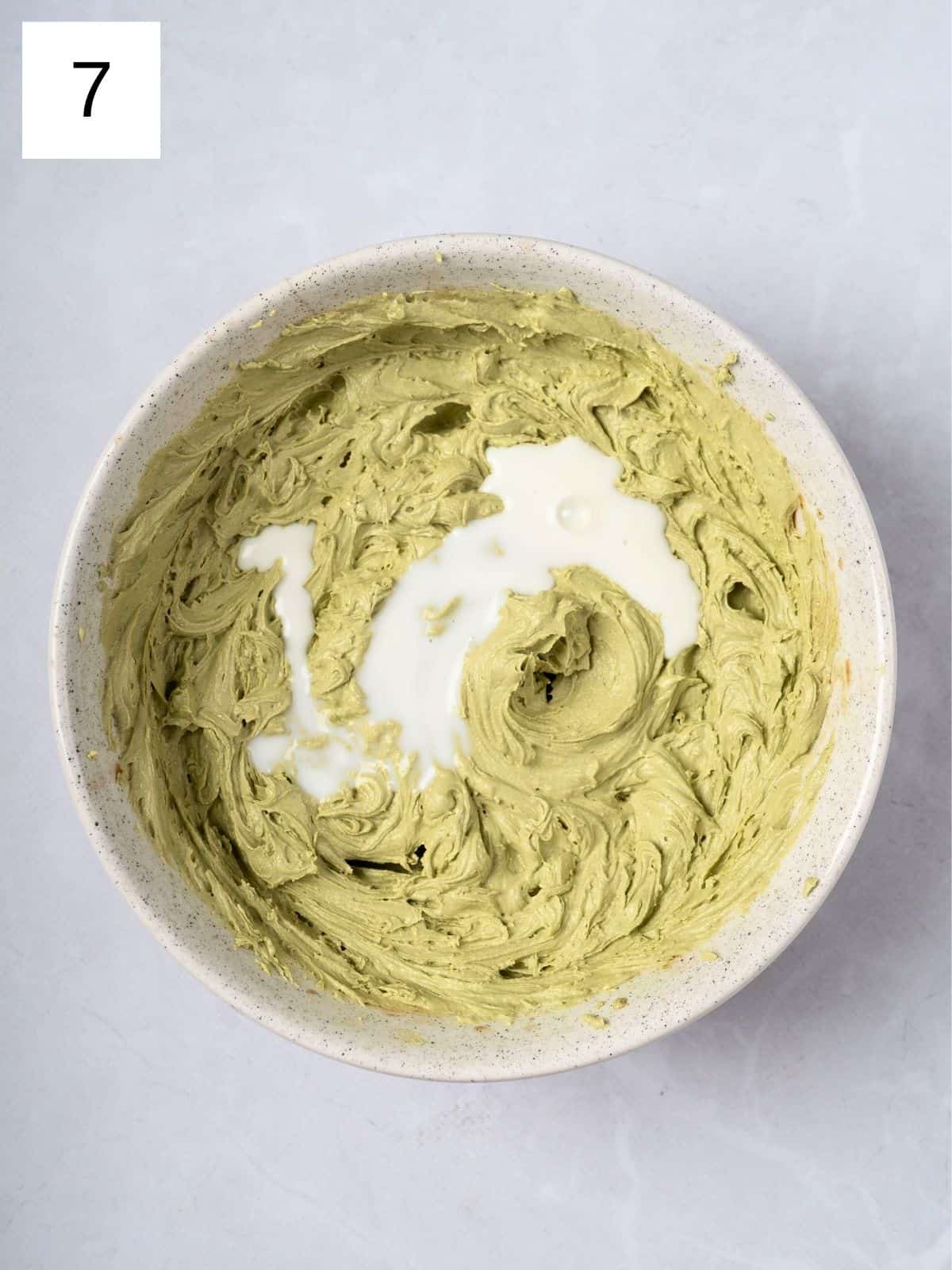 A bowl of matcha butter cream with milk.