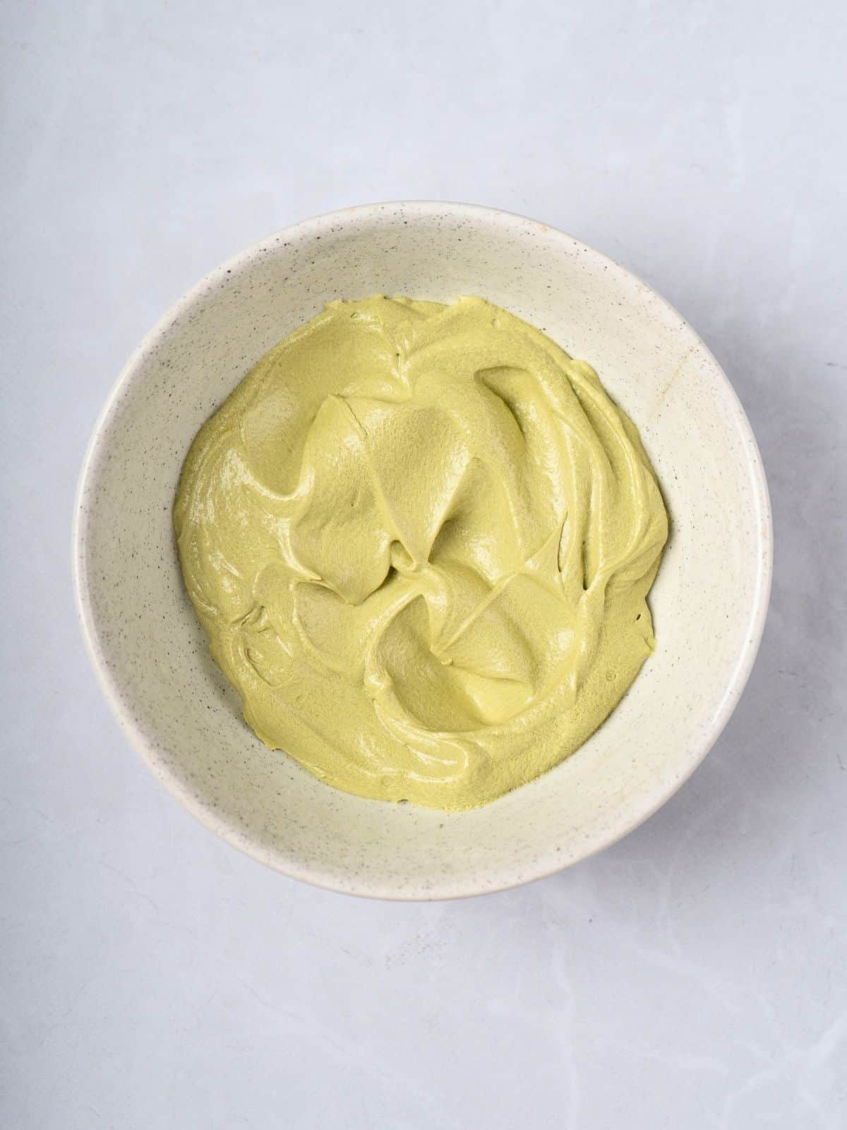 A bowl of matcha butter cream frosting.