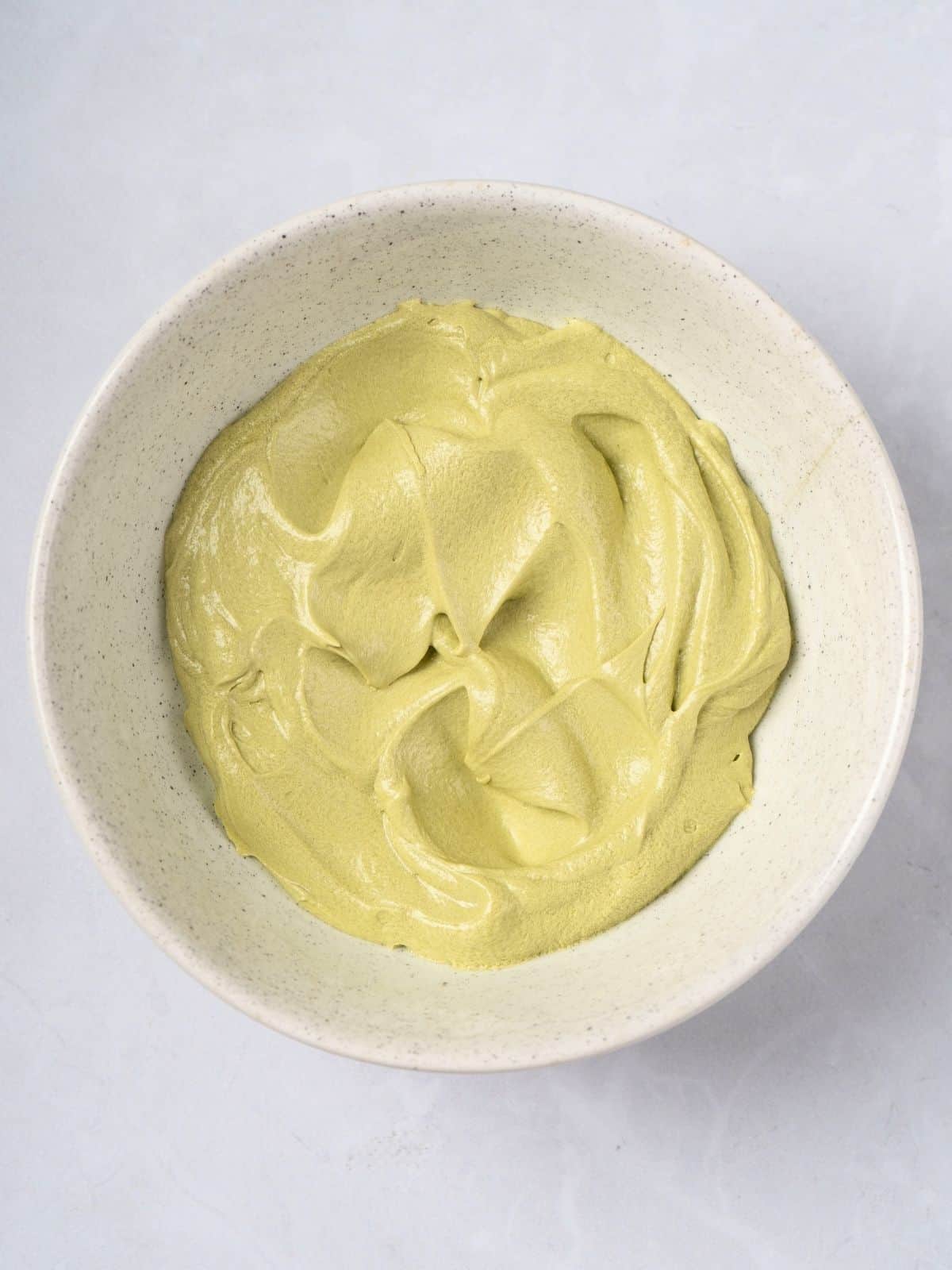 A bowl of matcha butter cream frosting.