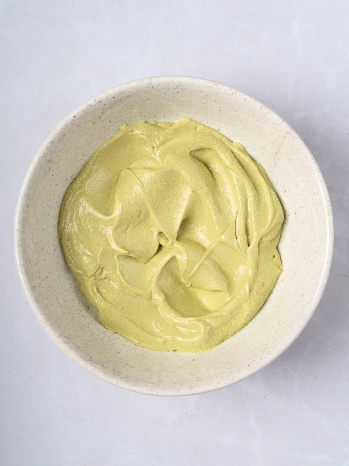 A bowl of matcha butter cream frosting.