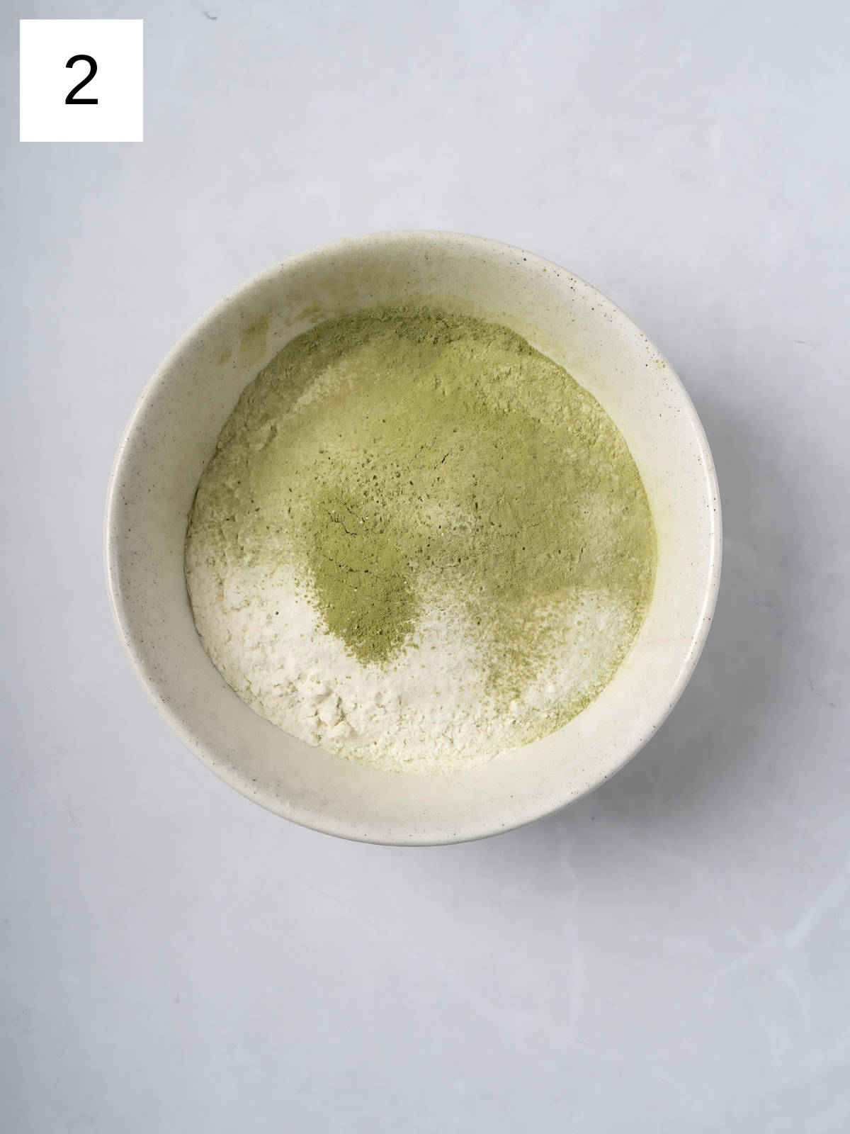 Matcha powder, salt , and baking powder mixture mixed together in a bowl.