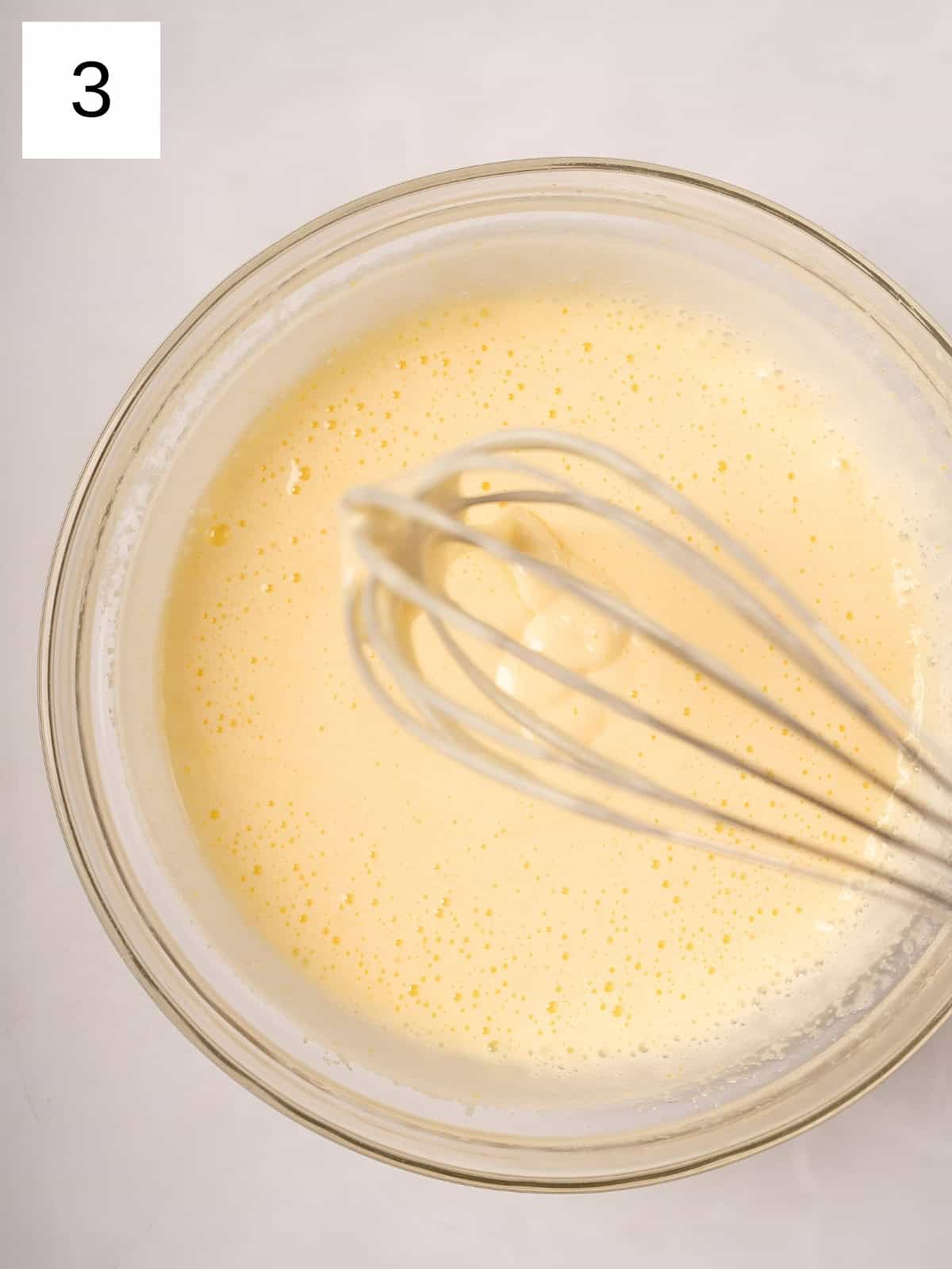 Egg and sugar being whisked in a bowl.