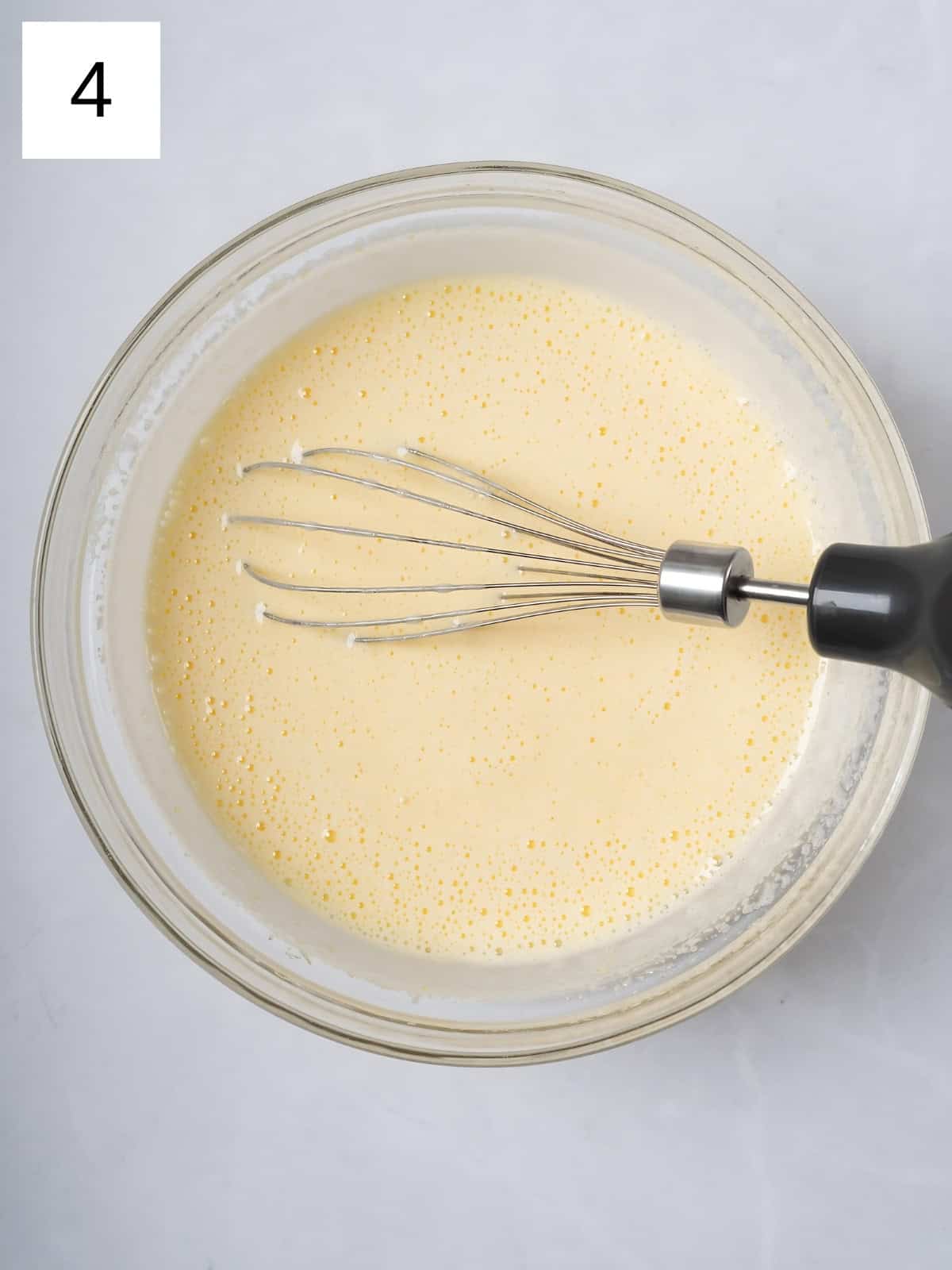 Egg and sugar being whisked in a bowl.