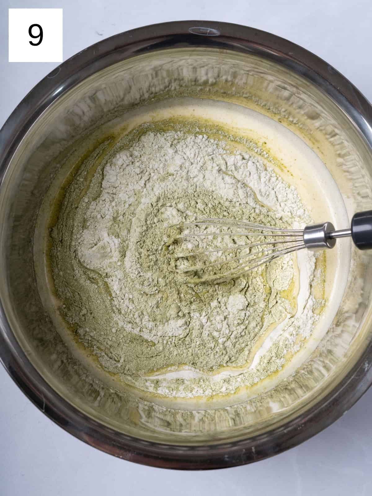 A mixture of egg and matcha being continually whisked in a bowl.