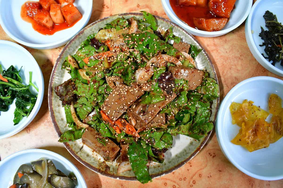 A bowl of acorn jelly along with other side dishes.