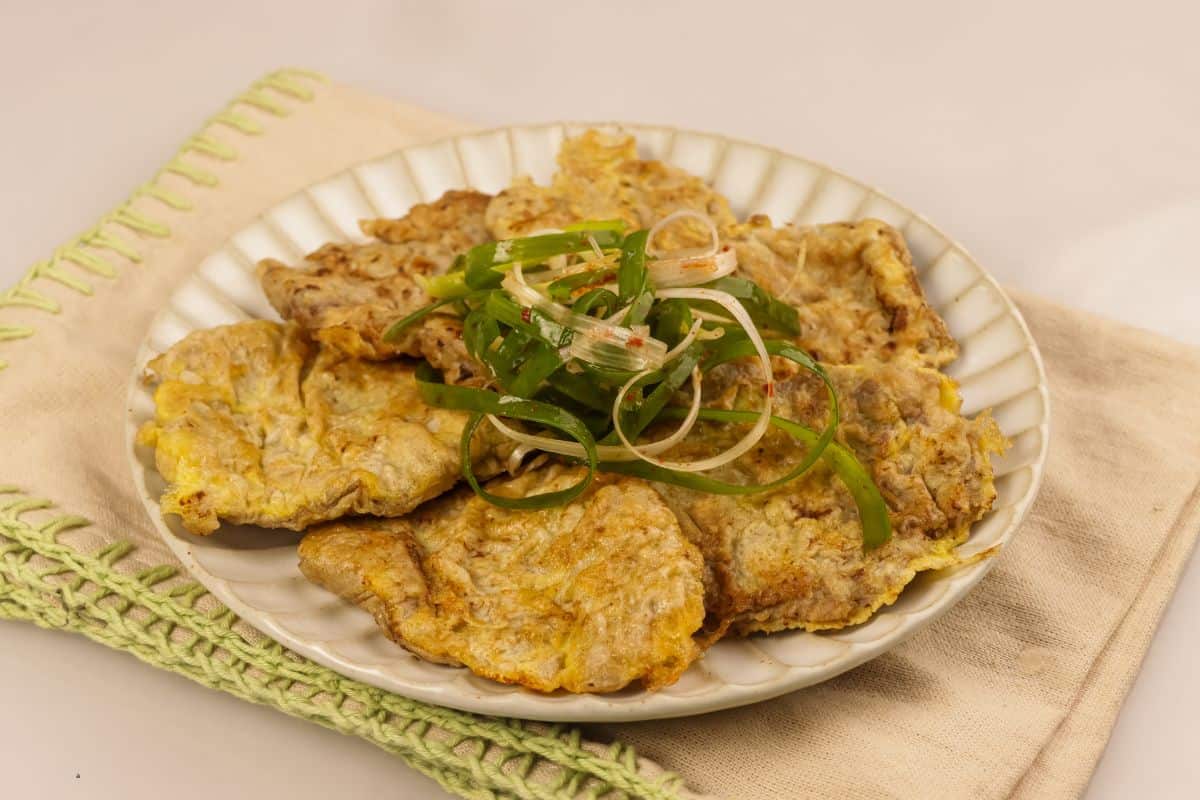 A plate of mayak yukjeon with spring onion toppings.