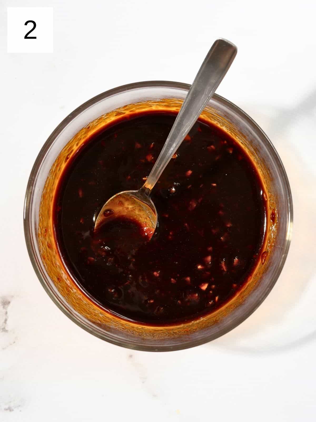 A bowl of mixed soy sauce, gochujang, and garlic.