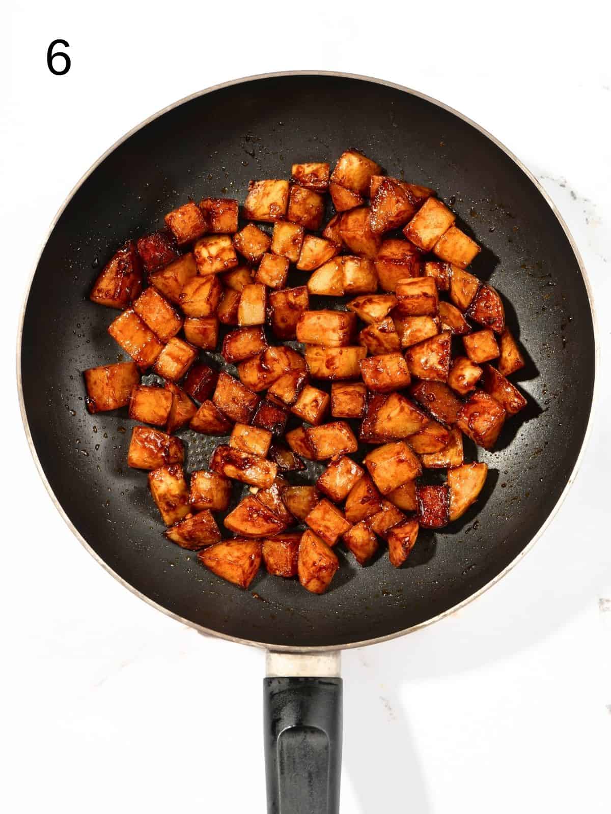 Pan fried gochujang potatoes in a pan.