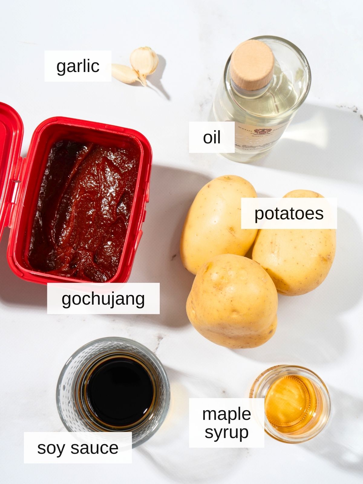 Gochujang potatoes recipe ingredients including gochujang, oil, garlic, potatoes, soy sauce, and maple syrup.