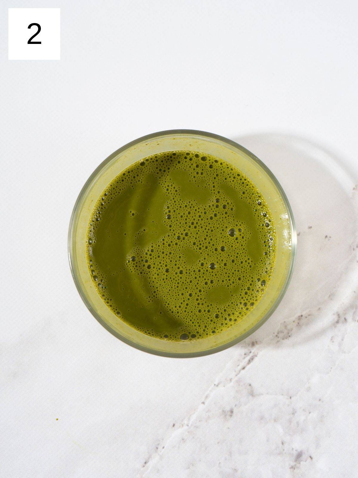 Mix matcha powder with hot water until it blends smoothly.