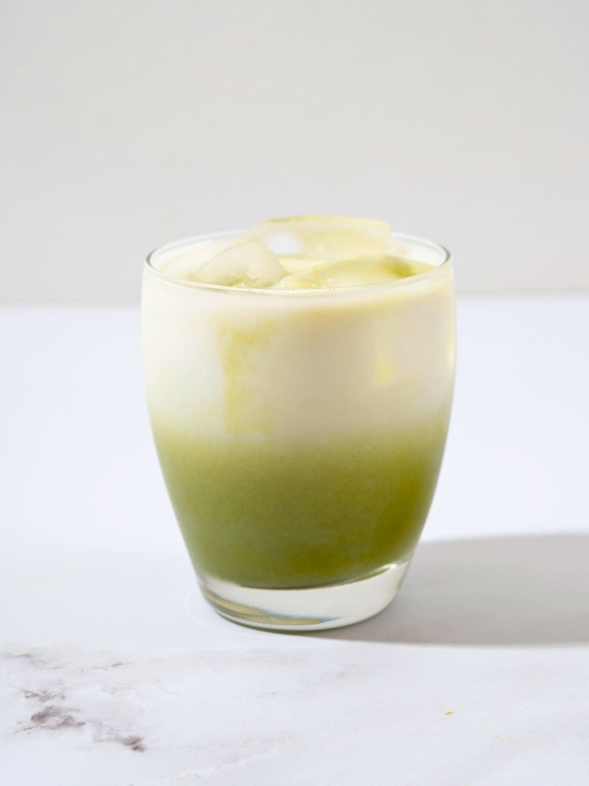  a nicely layered glass of matcha latte.