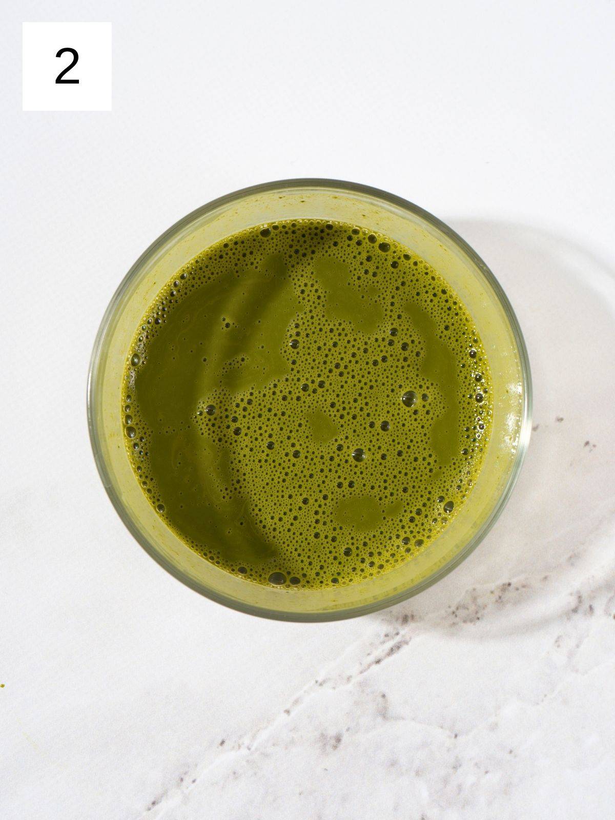 Matcha powder smoothly mixed with hot water.