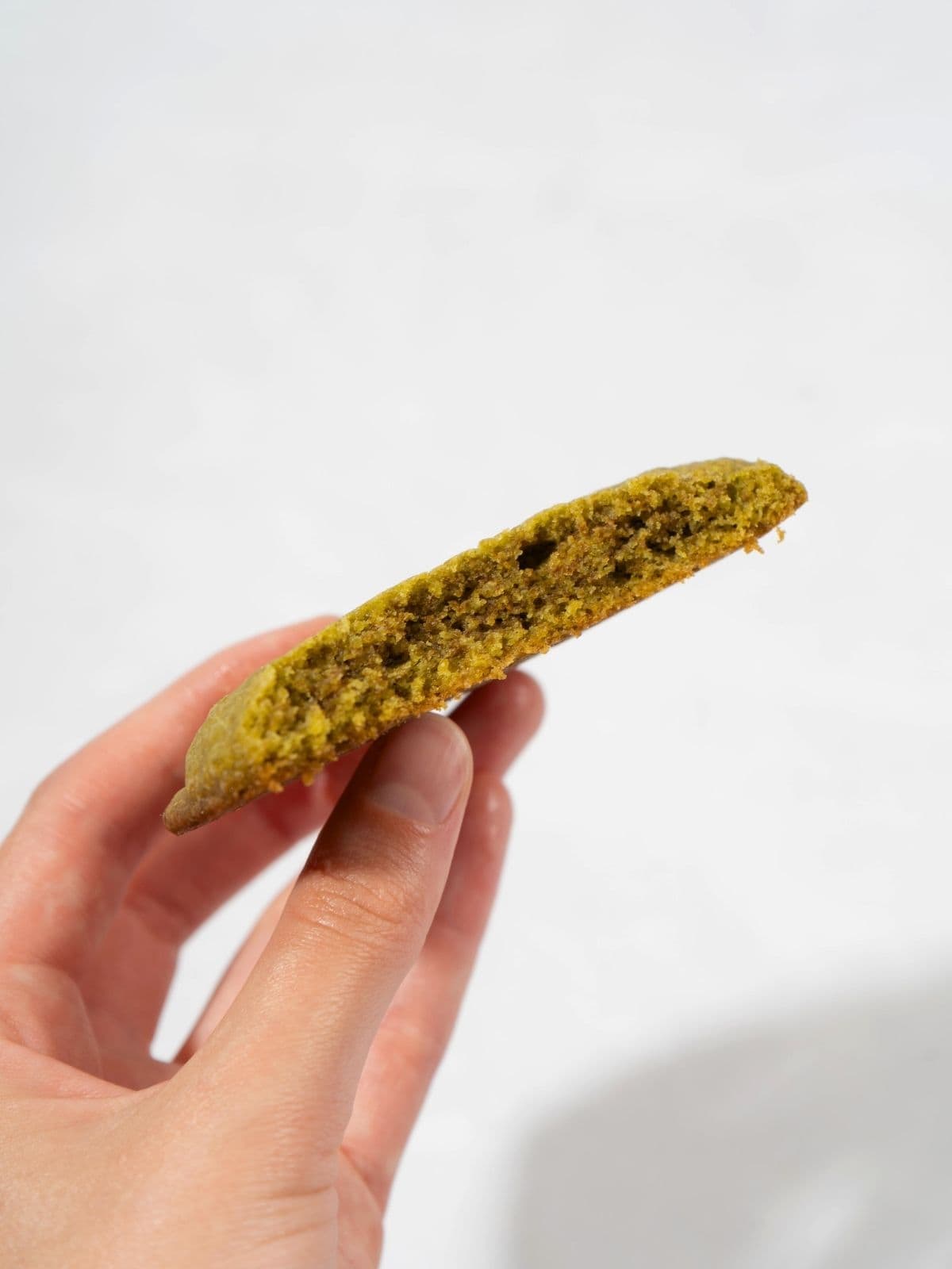 A person holding a matcha cookie.