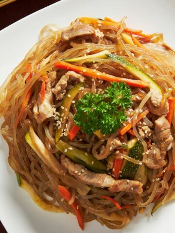 A plate of japchae with side dishes.