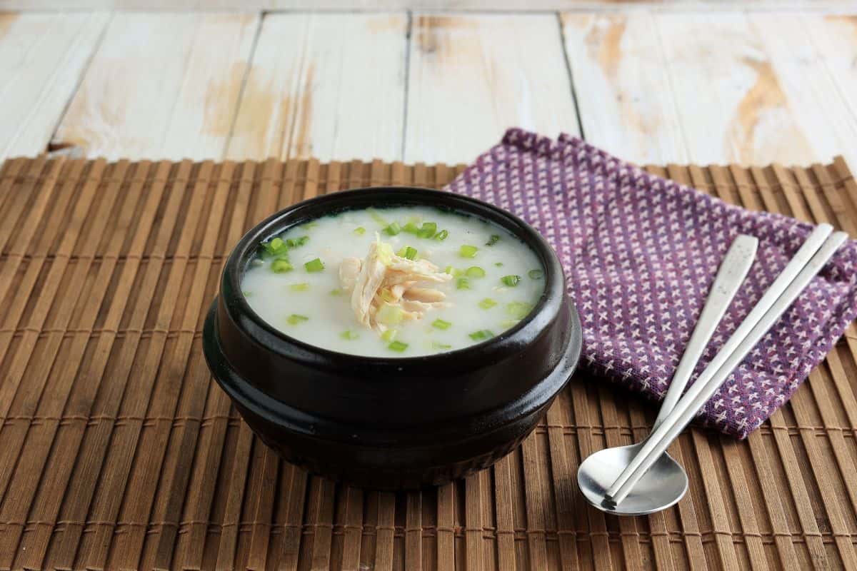 A small black bowl of dak juk or Korean chicken porridge.