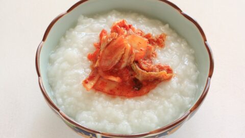 A nice bowl of Korea porridge with kimchi toppings.