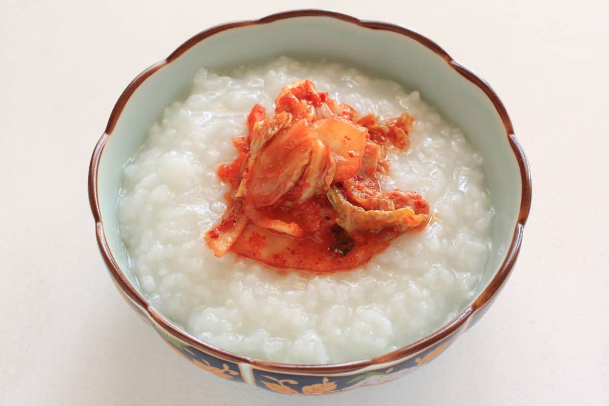 A nice bowl of Korea porridge with kimchi toppings.