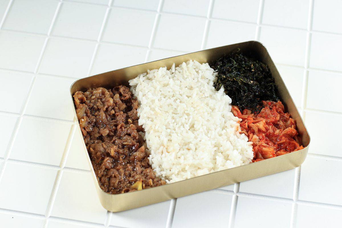 Dosirak Korean Lunchbox Packed Meal Containing Rice, Kimchi, Meat, Seaweed Flakes.