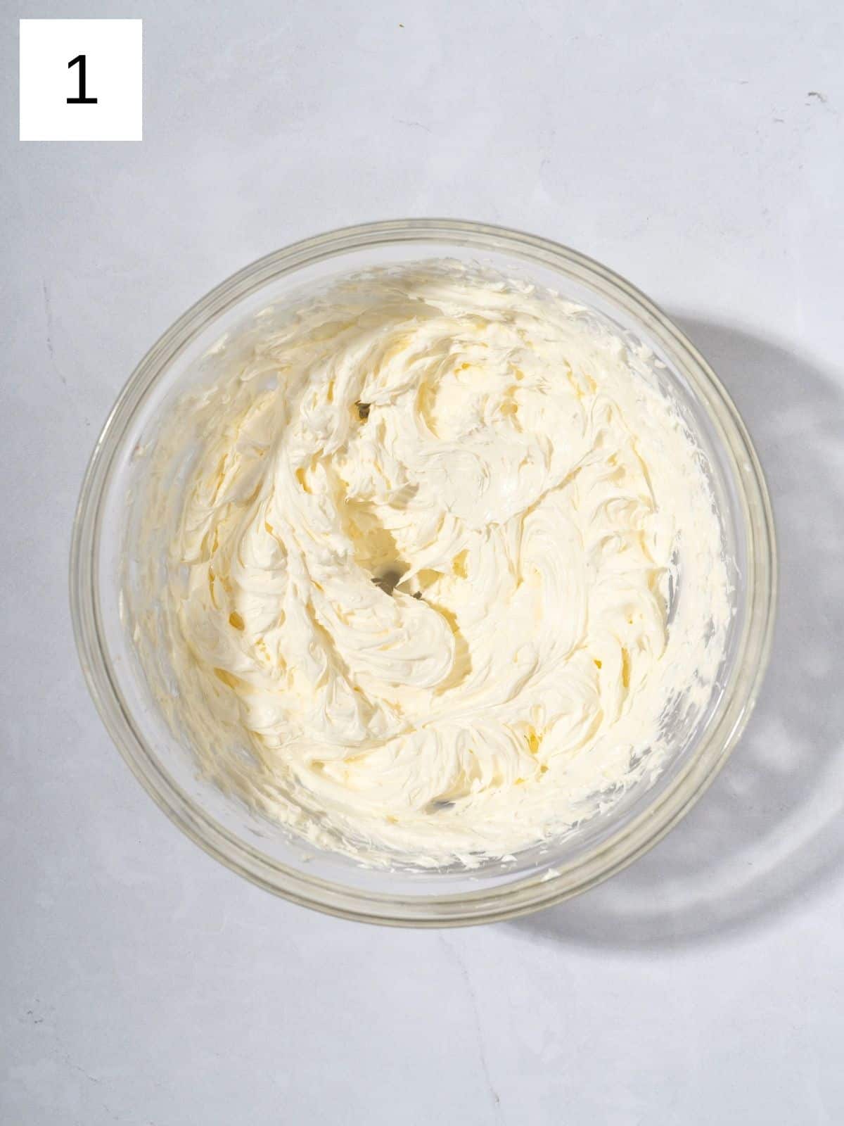 A bowl filled with beaten softened unsalted butter.