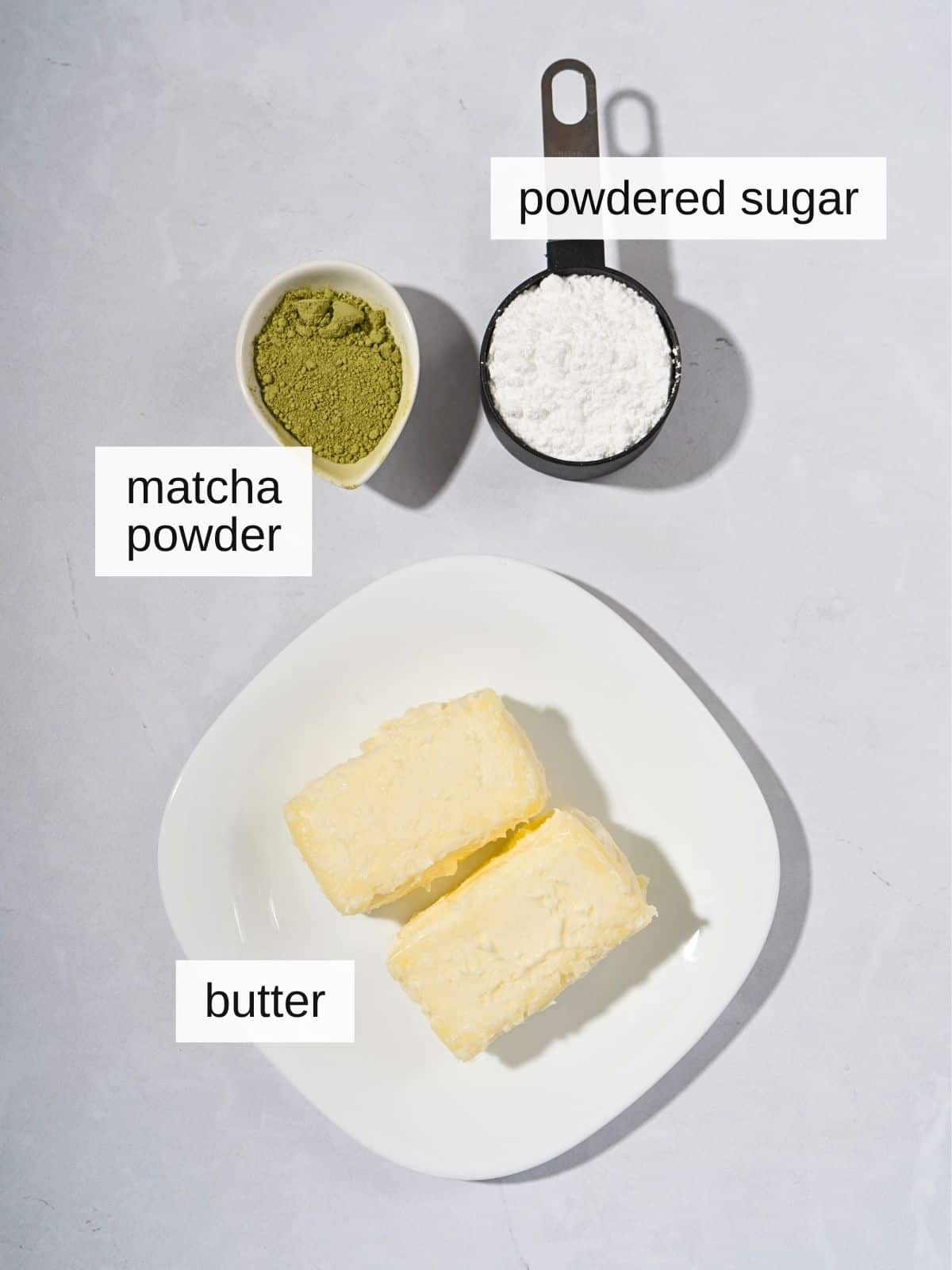 Ingredients for whipped matcha butter, including powdered sugar, matcha powder, and butter.