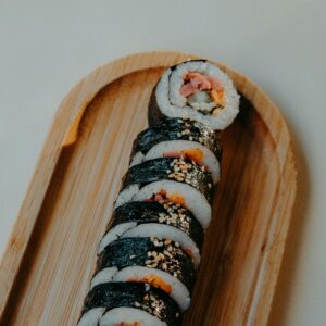 Kimbap served on a wooden plate.