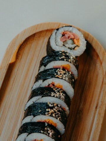 Kimbap served on a wooden plate.