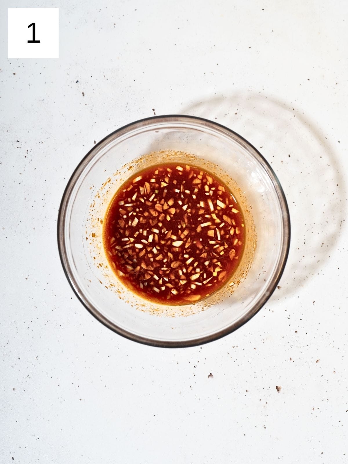 A bowl containing the honey gochujang nmixture. 
