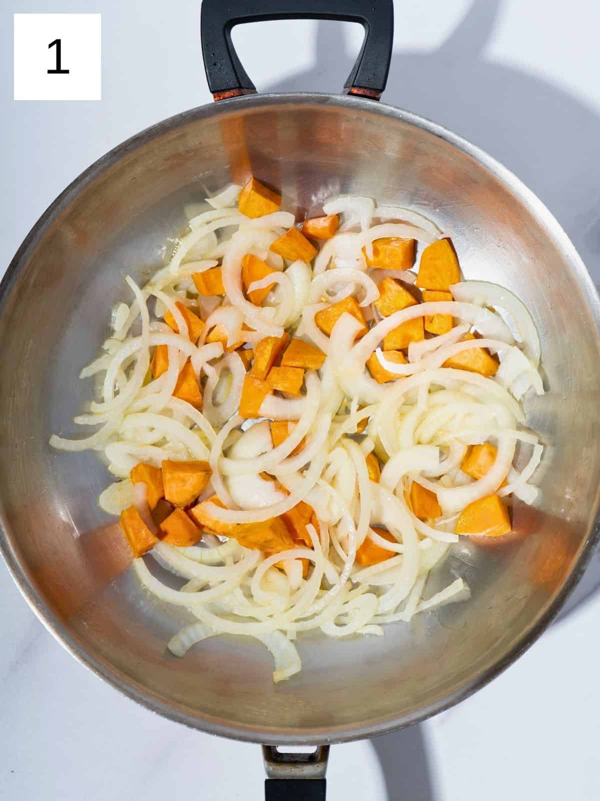 Diced sweet potatoes and sliced onions sautéing in a large wok, sizzling in sesame oil and creating a colorful, aromatic base for a stir fry.