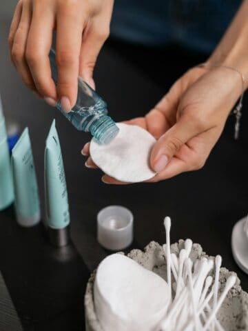 Person putting toner on a cotton pad.