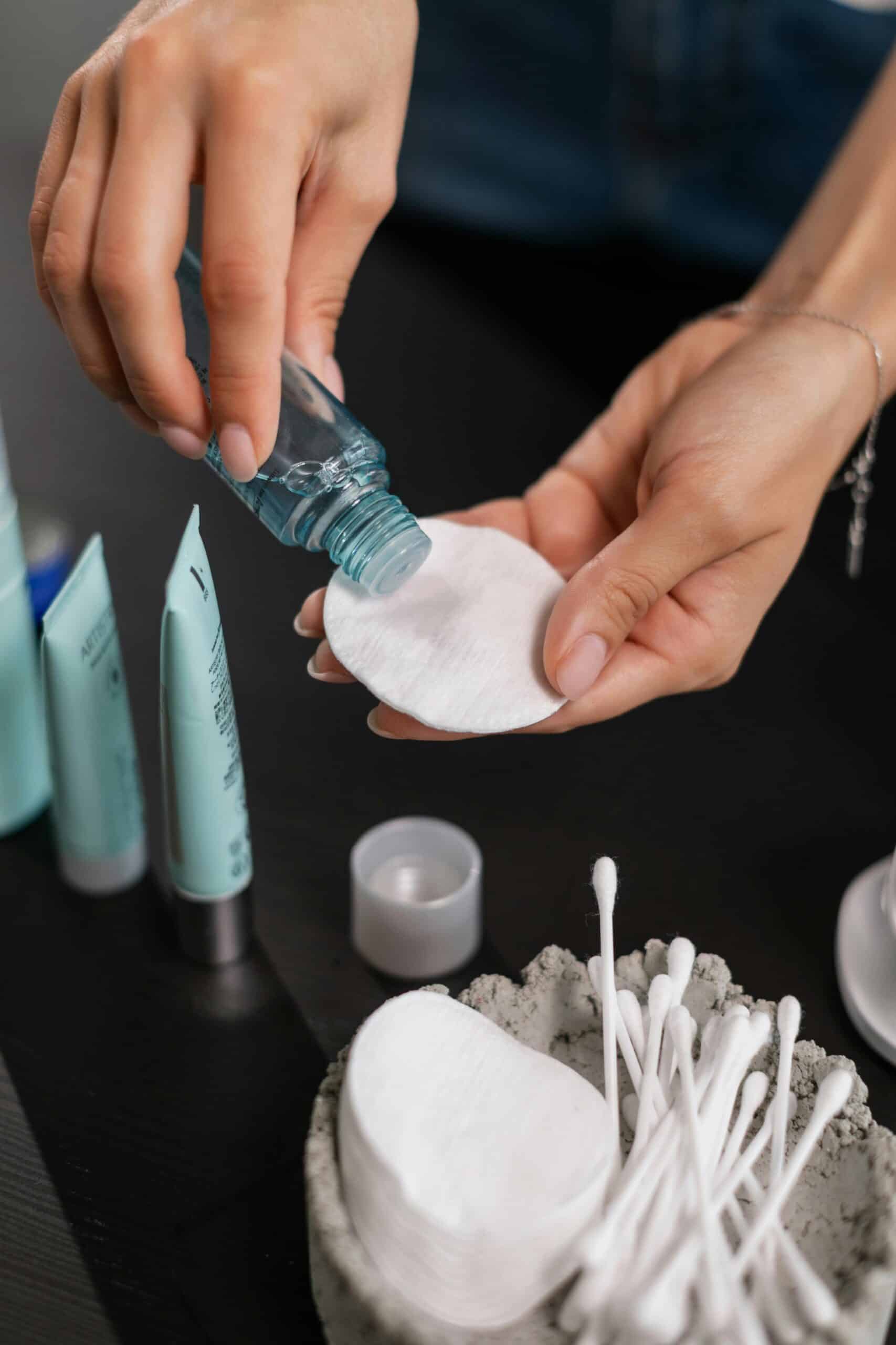 Person putting toner on a cotton pad.