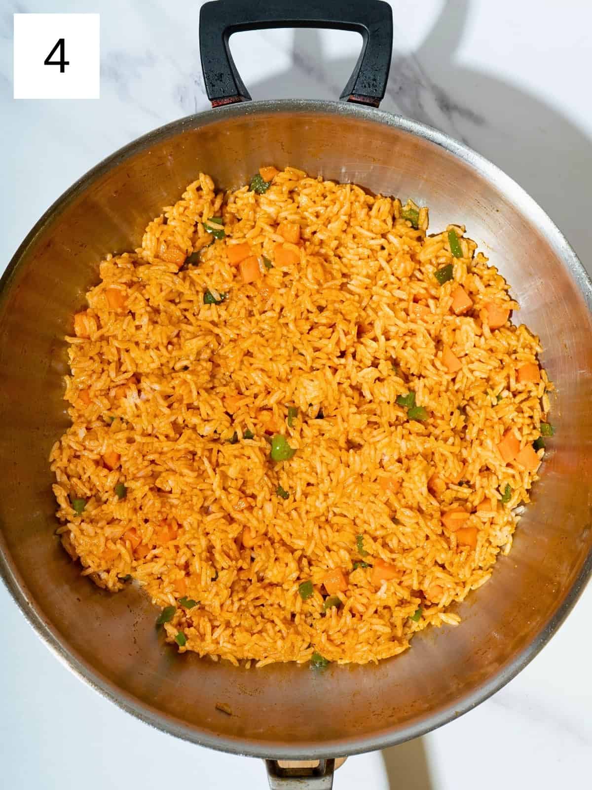 A flavorful mixture of rice and vegetables sautéed with gochujang, soy sauce, and salt in a skillet, creating a vibrant and spicy dish.