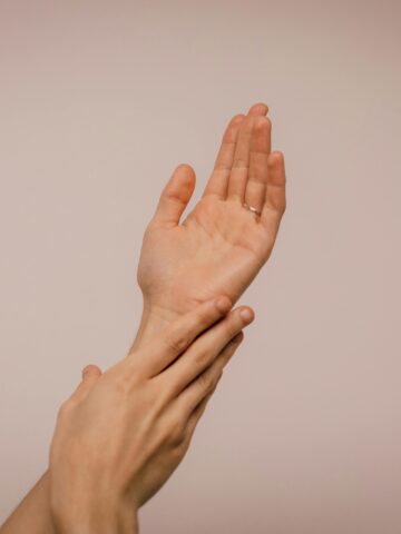 A minimalist shot of hands applying Korean skincare for acne-prone skin, emphasizing hydration and skin barrier protection.