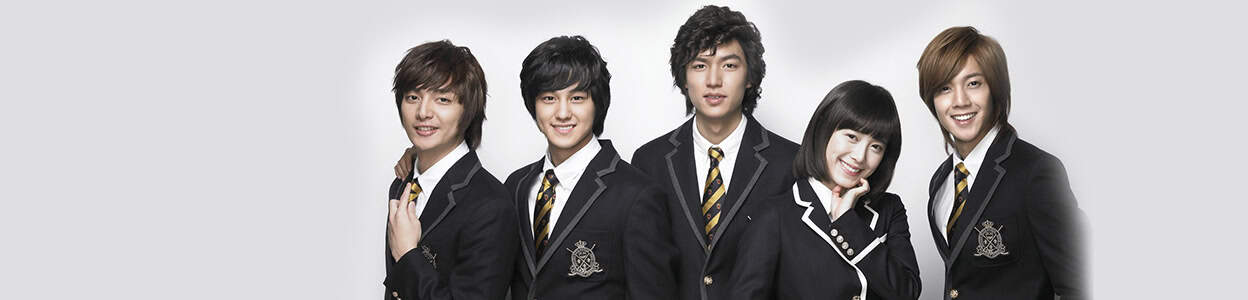 The full cast lineup of Boys Over Flowers in their school uniforms, smiling and standing in a row against a light grey background.