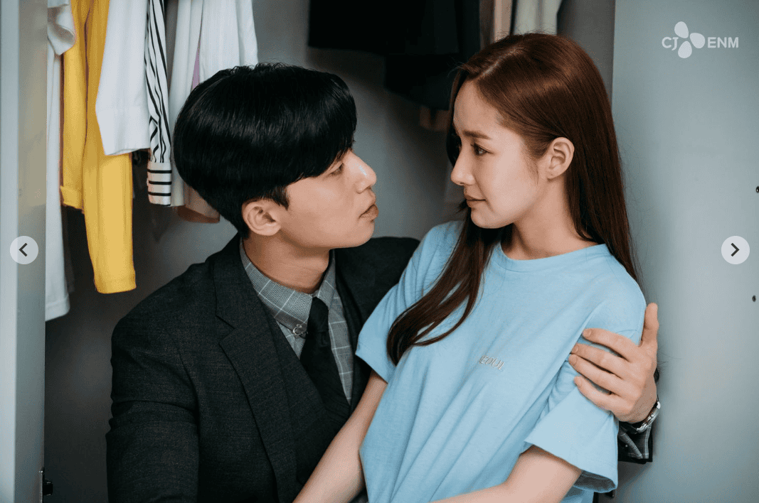 Lee Young-joon and Kim Mi-so sitting closely inside a closet, sharing a deep, intimate gaze with their arms around each other.