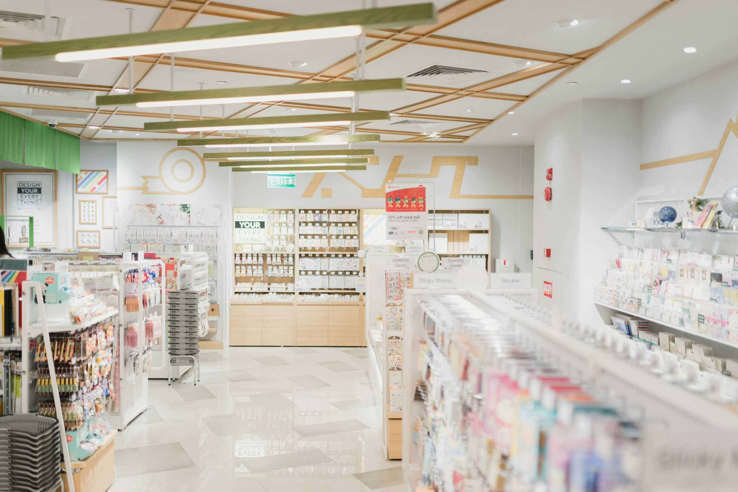 Wide-angle view of a well-lit modern drugstore, filled with skincare and personal care products on neatly organized shelves.