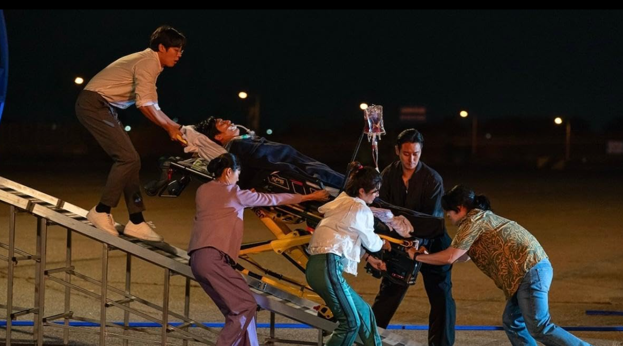 A trauma team carrying a patient on a gurney.